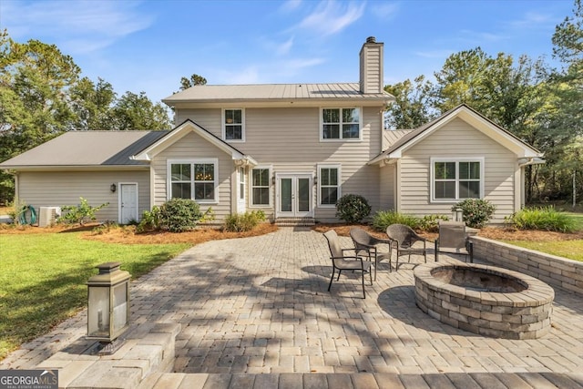 back of property featuring a patio area and a fire pit