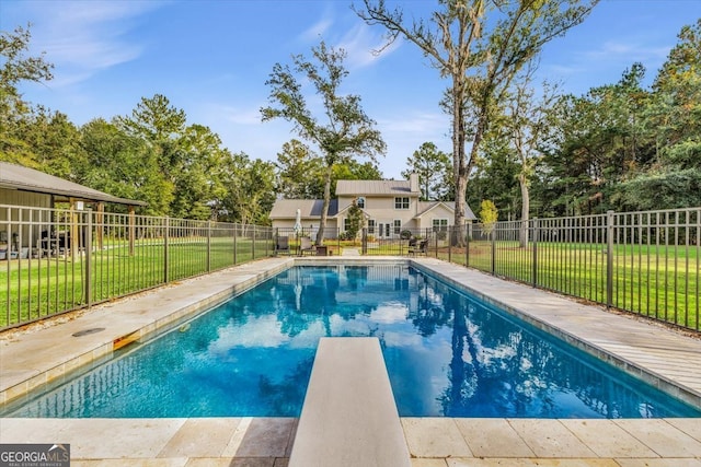 view of pool featuring a yard and a diving board