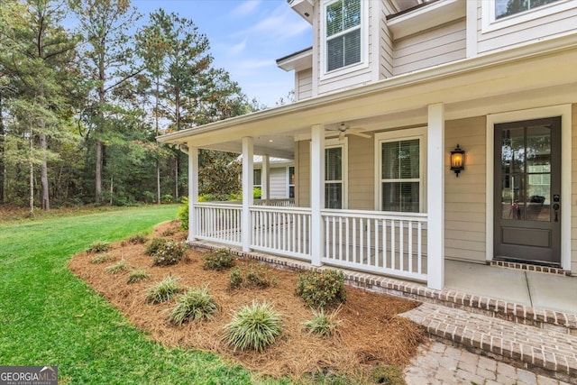 property entrance featuring a porch, a lawn, and ceiling fan