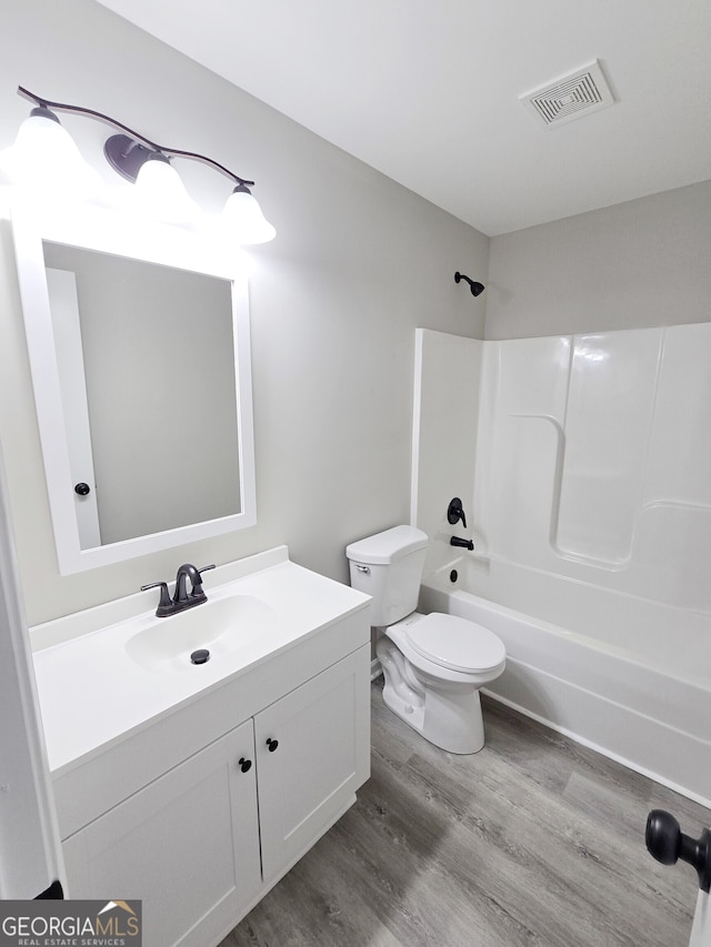 full bathroom featuring vanity, hardwood / wood-style floors, bathing tub / shower combination, and toilet