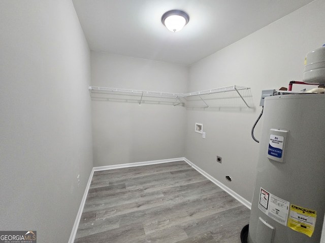 washroom with hookup for an electric dryer, electric water heater, wood-type flooring, and washer hookup