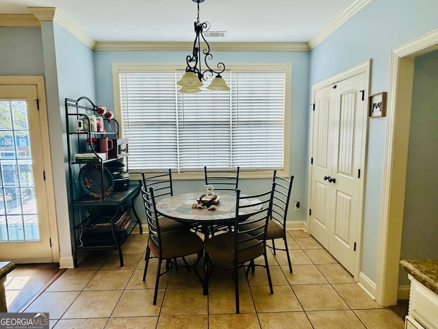 tiled dining space featuring a chandelier and crown molding