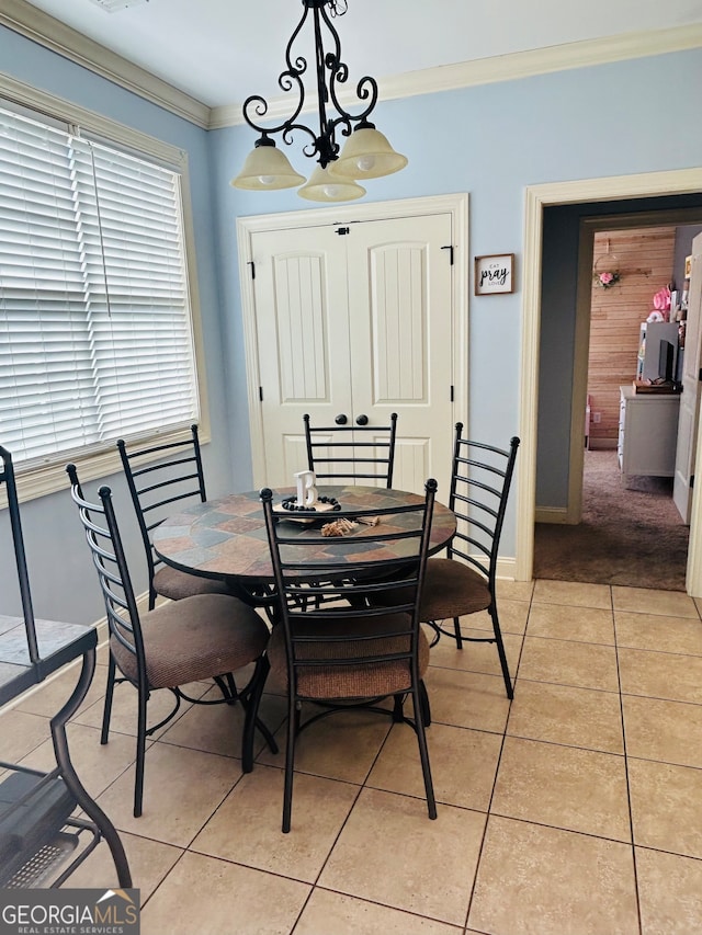 tiled dining space featuring crown molding and an inviting chandelier