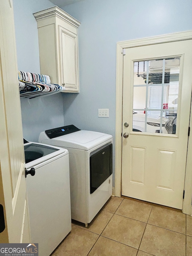 washroom featuring cabinets, separate washer and dryer, and light tile patterned floors