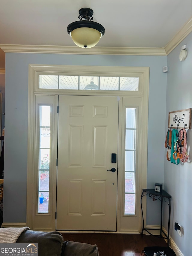 foyer with ornamental molding and dark hardwood / wood-style flooring