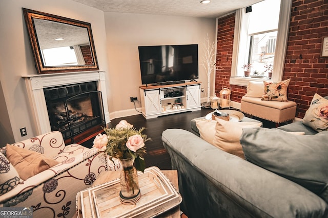 living room featuring a textured ceiling, brick wall, and wood-type flooring