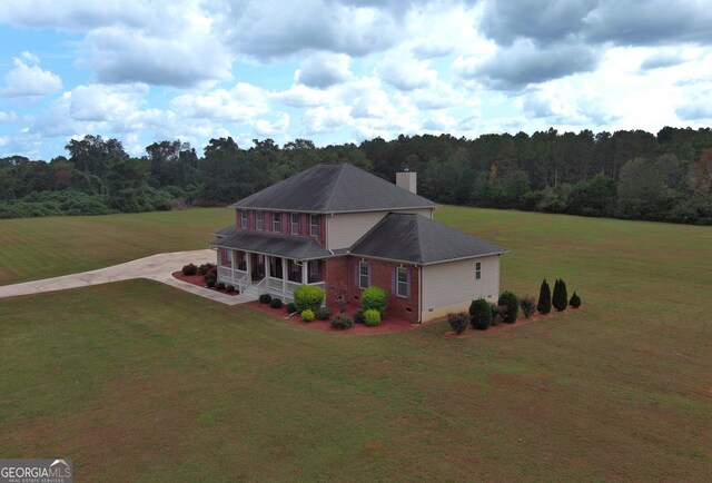 view of front of house featuring an outbuilding, a porch, a garage, and a front lawn