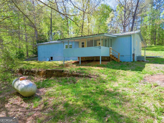 exterior space with a front lawn and central AC