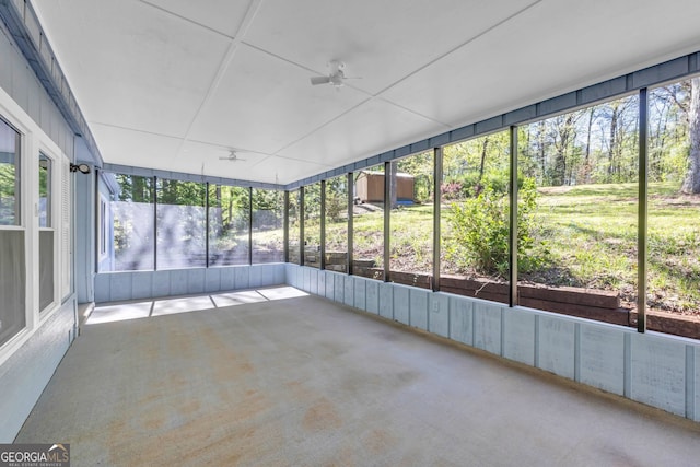 unfurnished sunroom with ceiling fan and a wealth of natural light