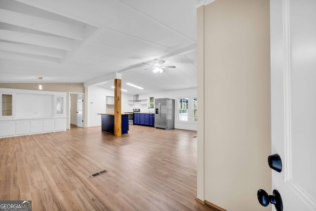 unfurnished living room with vaulted ceiling with beams, light hardwood / wood-style flooring, and ceiling fan