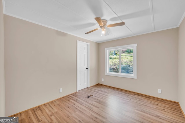 empty room featuring light hardwood / wood-style flooring, crown molding, and ceiling fan