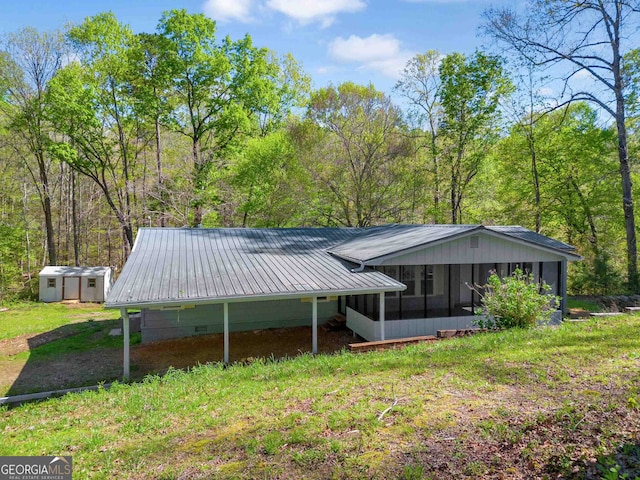 back of house featuring an outbuilding and a sunroom