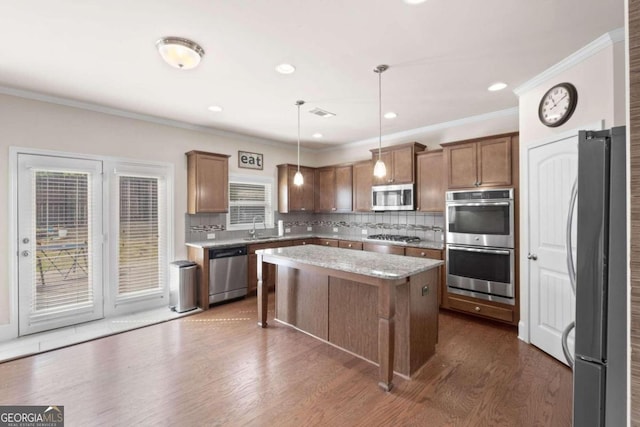 kitchen featuring pendant lighting, a center island, stainless steel appliances, and a wealth of natural light