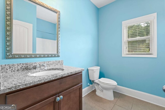 bathroom with tile patterned flooring, vanity, and toilet