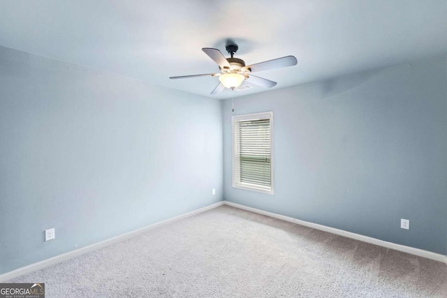 carpeted spare room with ceiling fan