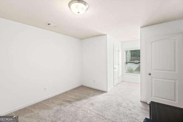 spare room featuring light colored carpet