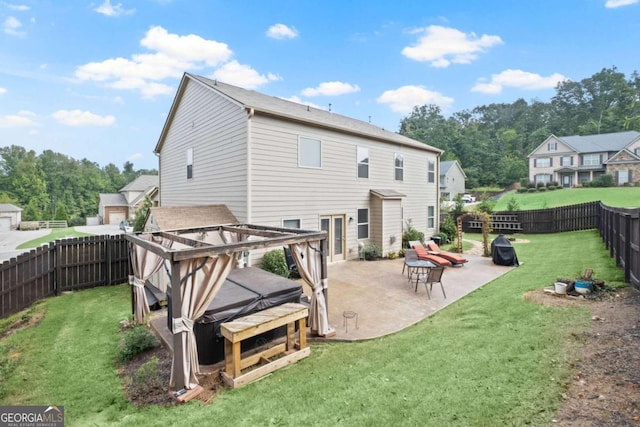 back of property featuring a hot tub, a patio area, and a lawn