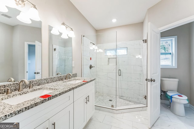 bathroom featuring vanity, toilet, and a shower with shower door