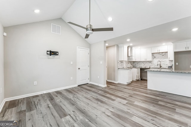 unfurnished living room with light wood-type flooring, high vaulted ceiling, ceiling fan, and sink