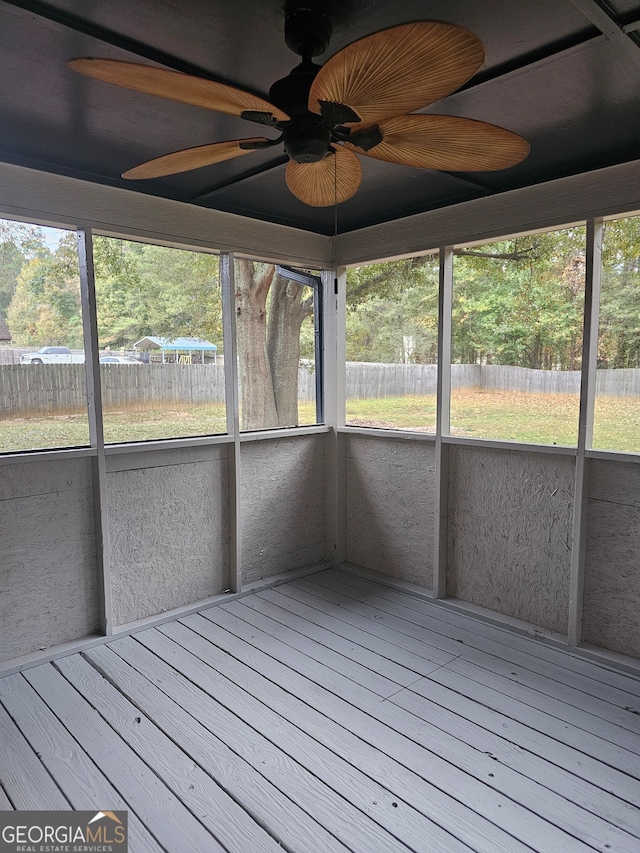 unfurnished sunroom featuring a wealth of natural light and ceiling fan