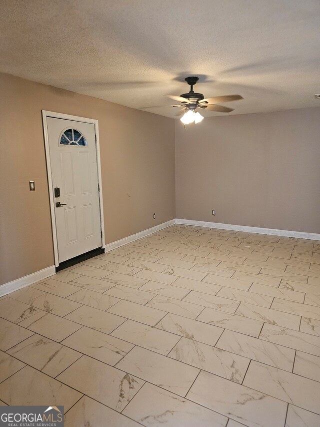 foyer with a textured ceiling and ceiling fan