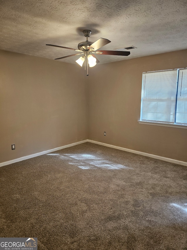 spare room featuring a textured ceiling, carpet floors, and ceiling fan