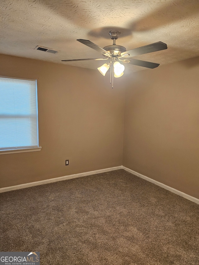 carpeted spare room featuring a textured ceiling and ceiling fan