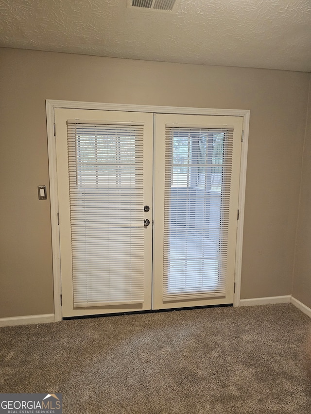 doorway to outside with french doors, carpet, and a textured ceiling