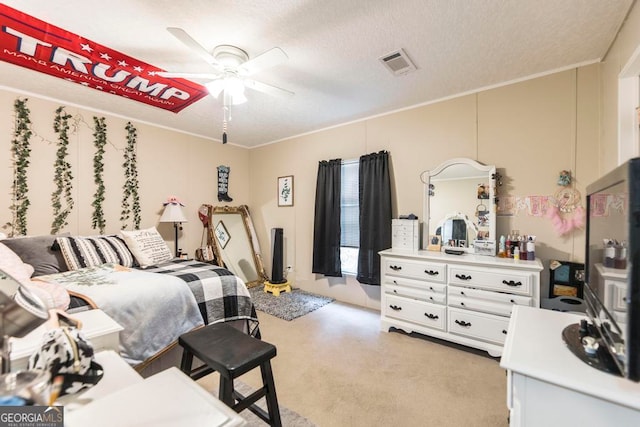 bedroom featuring ornamental molding, a textured ceiling, light colored carpet, and ceiling fan