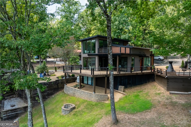 back of property featuring a patio and a fire pit