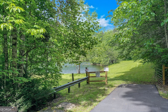 surrounding community featuring a water view and a yard