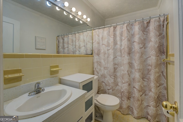 bathroom featuring ornamental molding, a textured ceiling, vanity, toilet, and tile walls