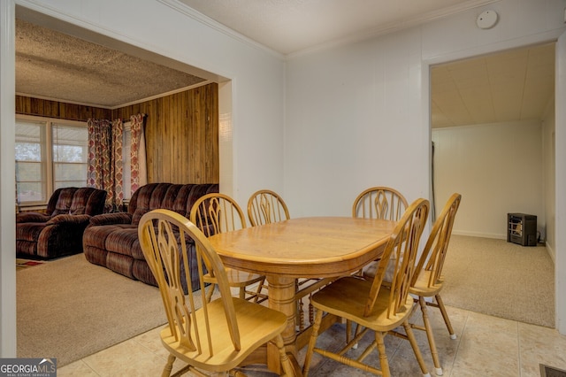 dining room with wooden walls, light tile patterned floors, a textured ceiling, and ornamental molding