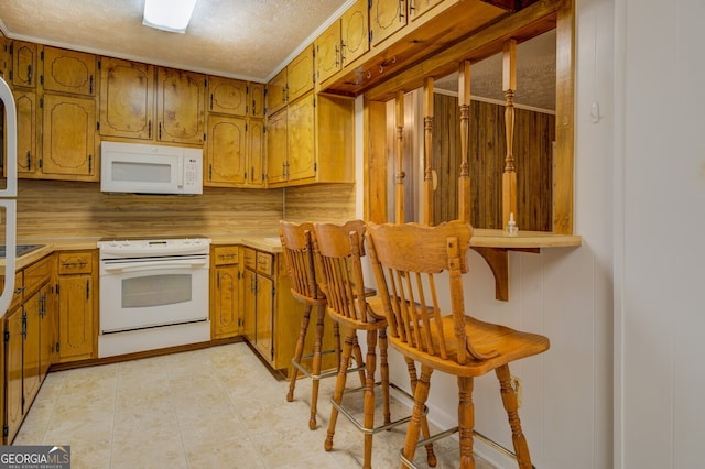 kitchen featuring white appliances, a textured ceiling, and decorative backsplash