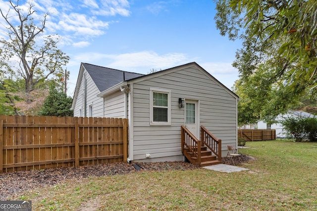 rear view of property featuring a yard