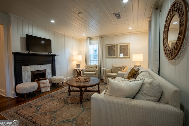 living room with wooden walls, hardwood / wood-style floors, a high end fireplace, and wooden ceiling