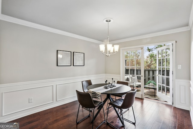 dining area featuring dark hardwood / wood-style flooring, an inviting chandelier, and crown molding