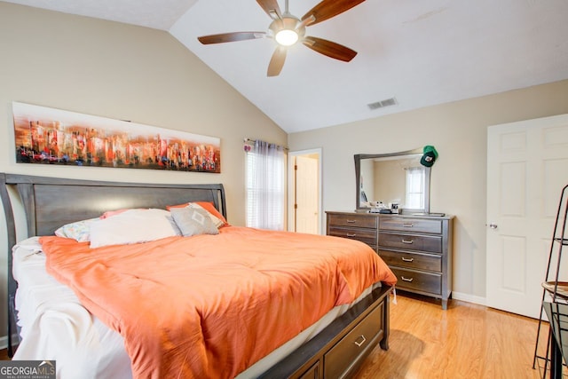 bedroom featuring light wood-type flooring, lofted ceiling, multiple windows, and ceiling fan