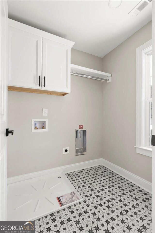 319 S Madison Ave, Monroe, GA 30655 - washroom with cabinet space, electric dryer hookup, washer hookup, tile patterned floors, and baseboards