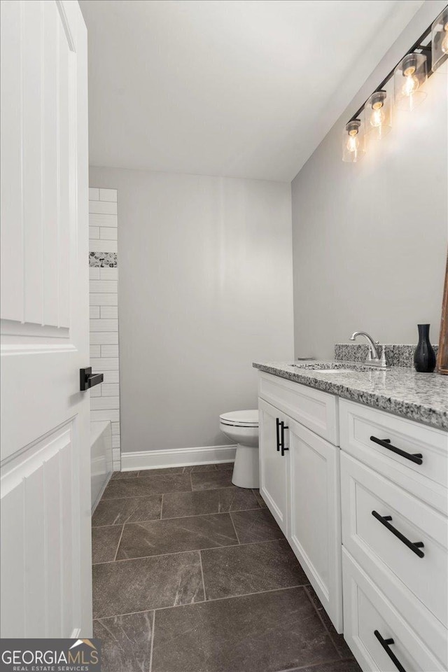319 S Madison Ave, Monroe, GA 30655 - bathroom with toilet, vanity, and baseboards