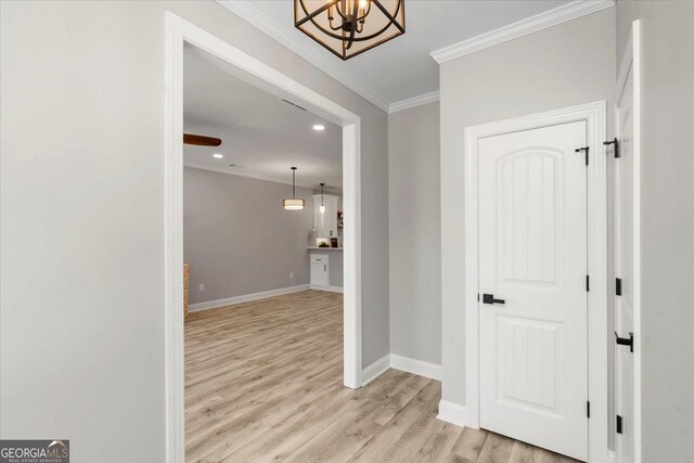 living room featuring ceiling fan, light hardwood / wood-style floors, and crown molding