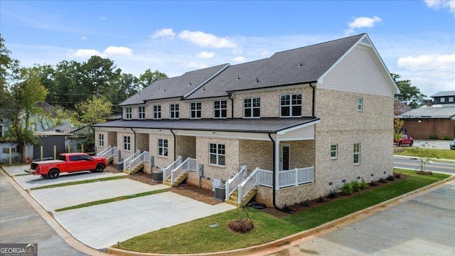 319 S Madison Ave, Monroe, GA 30655 - view of front of house featuring covered porch, brick siding, concrete driveway, and central AC unit