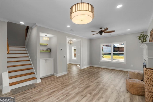 319 S Madison Ave, Monroe, GA 30655 - unfurnished living room with crown molding, stairway, light wood-style flooring, recessed lighting, and a ceiling fan