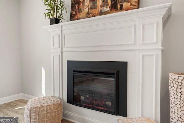 319 S Madison Ave, Monroe, GA 30655 - detailed view of wood finished floors, baseboards, and a glass covered fireplace