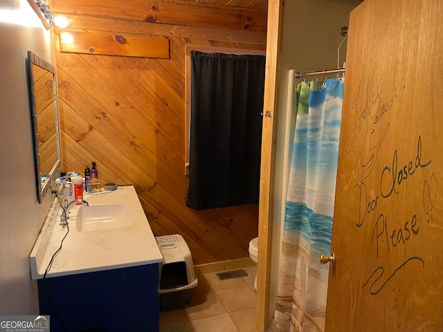 bathroom with tile patterned floors, toilet, curtained shower, wood walls, and vanity