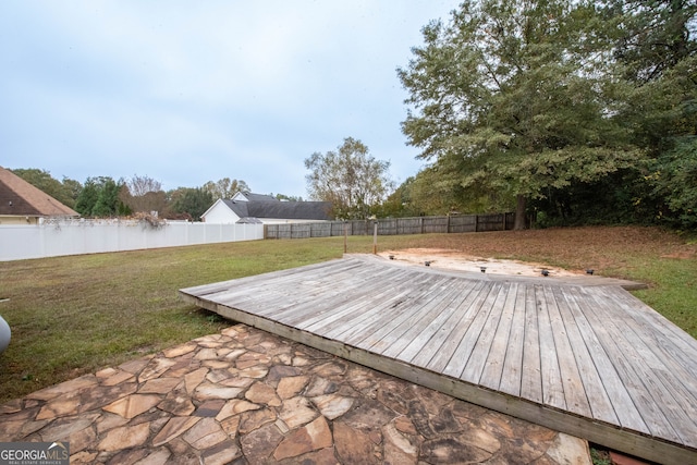 wooden deck with a water view and a lawn