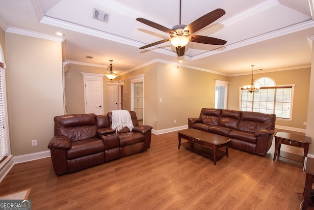 living room featuring ornamental molding, ceiling fan with notable chandelier, and wood-type flooring