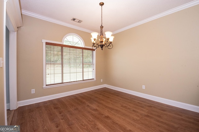 empty room featuring dark hardwood / wood-style floors, an inviting chandelier, and crown molding