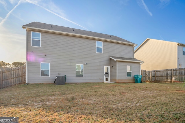 rear view of property with a lawn and central AC unit