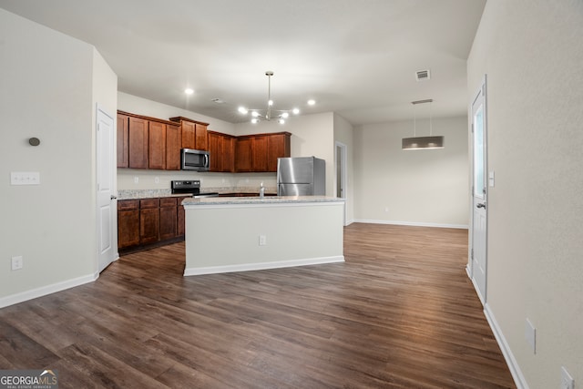 kitchen with an island with sink, hanging light fixtures, dark hardwood / wood-style floors, and appliances with stainless steel finishes